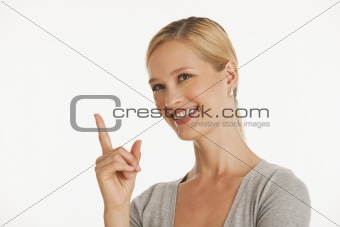 young woman pointing up towards copy space