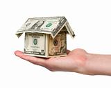 hand holding a small house built out of dollar bills