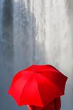 Woman With a Red Umbrella In Front Of A Waterfall