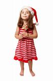 Little girl wearing santa hat and holding Christmas candy