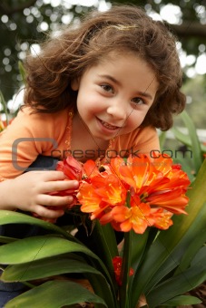 Little girl in a garden of clivia miniata