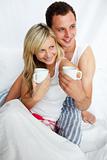 Couple in bed drinking coffee