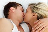 Amorous couple kissing in bed