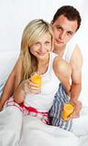 Couple drinking orange juice in bed