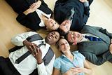 Business people lying in a circle on the floor