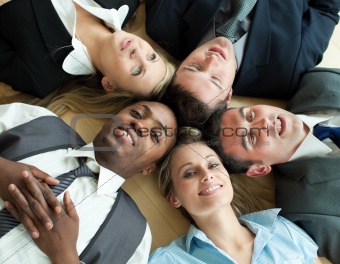 Closse-up of business people lying in a circle on the floor