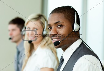 Businesspeople with headsets smiling at the camera