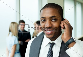 Ethnic businessman on phone in office
