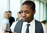 Afro-American businessman texting in office