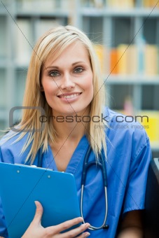 Young blond doctor at work smiling at the camera