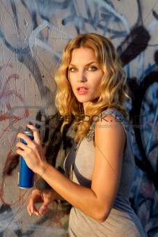 Woman spraying graffiti on a wall