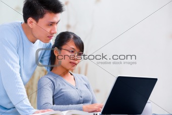 Couple using laptop at home