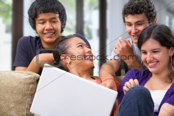 Teenagers discussing something interesting on laptop