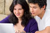 Young couple watching something on laptop