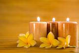 Aromatic candles with frangipani on bamboo mat