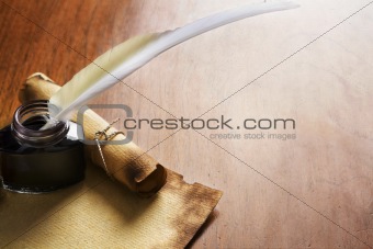 Old paper, scroll and quill pen on wooden paper