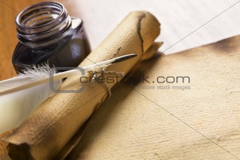 Old paper, scroll and quill on wooden table