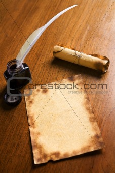 Old paper, quill pen and scroll on wooden table