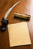 Old paper, quill pen and scroll on wooden table
