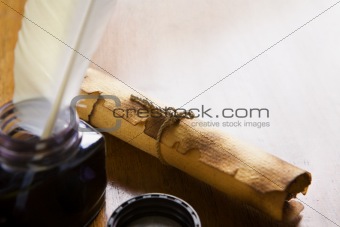 Scroll and quill pen on wooden table