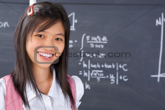 Student pose in front of blackboard