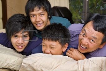 Father and sons having fun in bedroom