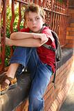 Boy with schoolbag slung over shoulder