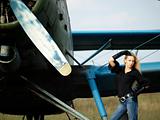 Young woman near vintage airplane