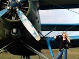 Young woman near vintage airplane