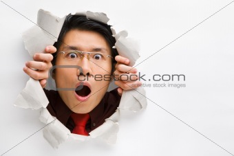 Man gazing surprisingly from hole in wall with copy space