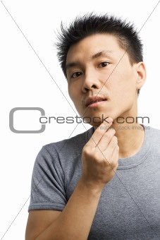 Asian man looking his unshaved chin