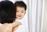 Asian toddler on her mother hug