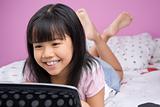 Young girl using laptop in her bedroom