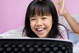 Little girls laughing while watching laptop
