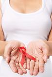 Woman showing red ribbon to support AIDS cause