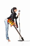 Rock-n-roll girl holding a guitar singing into retro microphone isolated on white