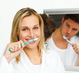 Portrait of an attractive woman cleaning her teeth with her boyf
