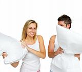 Young couple having a pillow fight with copy-space