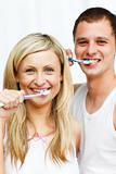 Couple cleaning their teeth smiling at the camera
