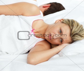 Upset couple in bed sleeping separate