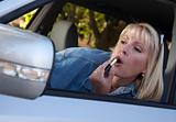Attractive Woman Putting on Lipstick While Driving.