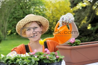 Young woman watering flowers