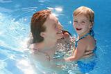 Blond daughter with redhead mother in pool