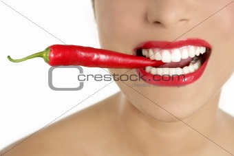 Beautiful woman teeth eating red pepper