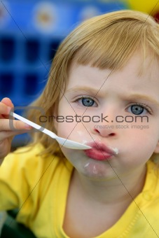 Blond little girl eating and gesturing