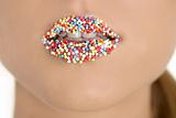 close up of woman lips with multicolored pearls