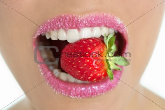 Delicious strawberry fruit in woman mouth