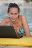 woman with laptop in pool