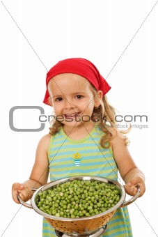 Happy healthy little girl with fresh peas