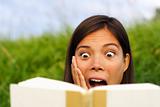 Shocked woman reading book